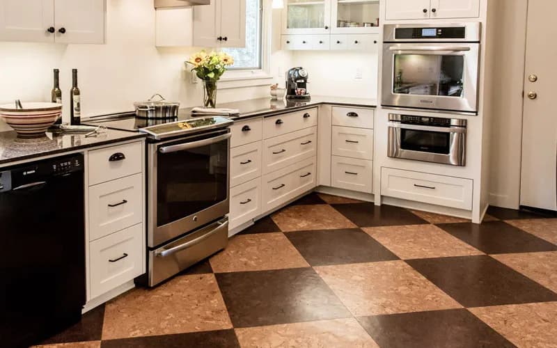 Modern kitchen with cream cabinetry, stainless steel appliances, and geometric cork flooring in brown and tan tones by Globus Cork.