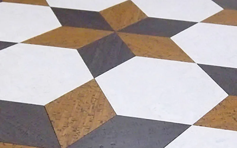 Cork and stone floor installation with geometric star pattern in warm brown, charcoal, and white tones by Globus Cork.