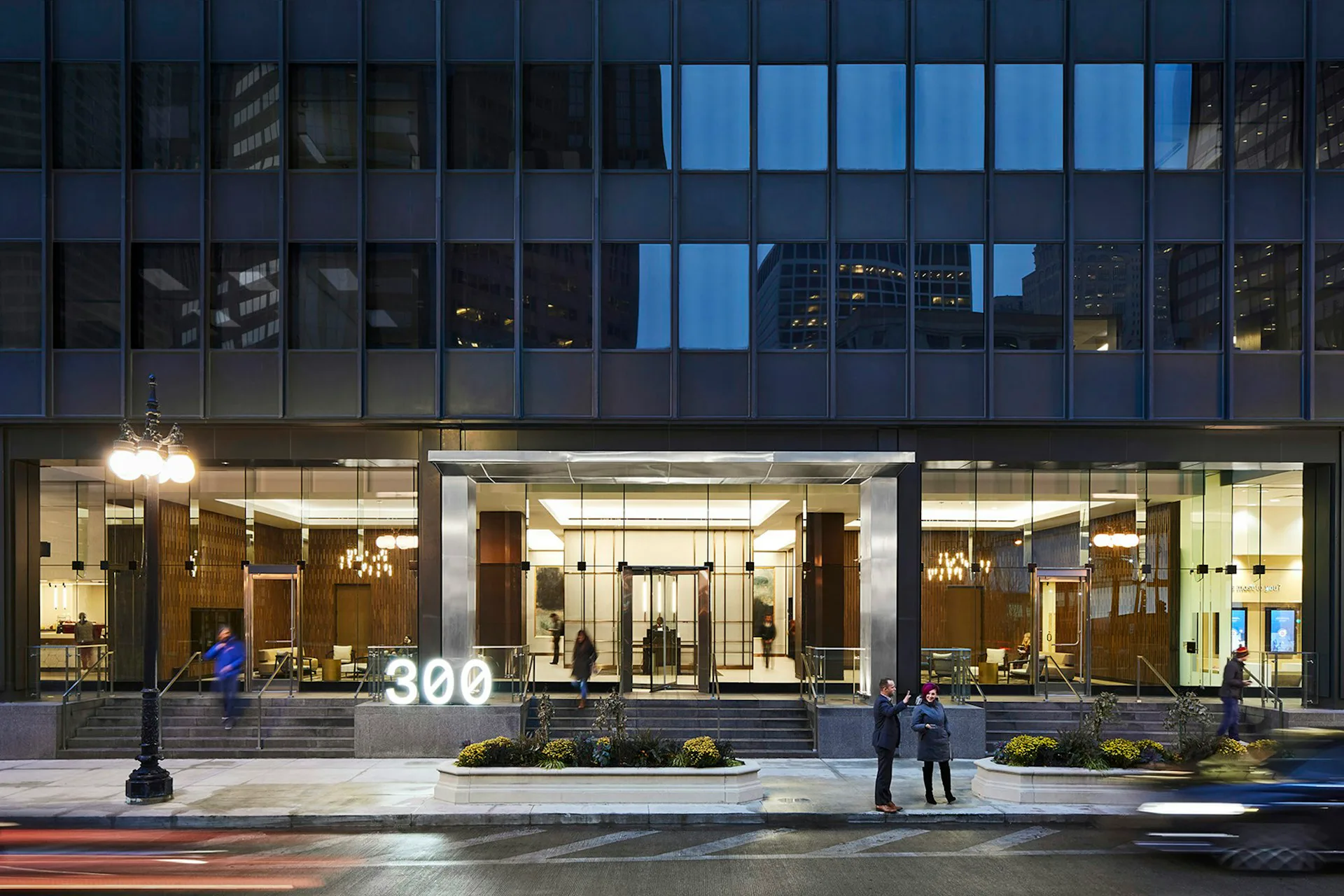Illuminated ground-floor retail storefront with polished dark flooring, warm interior lighting, and glass entrance at 300 by Huntsman Architectural Group.