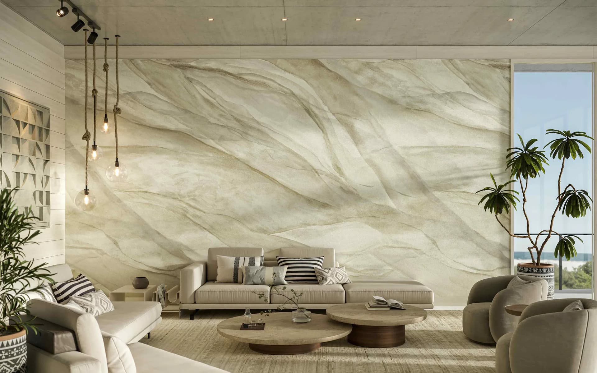 Luxurious living room with marble-textured wall installation, neutral beige furnishings, pendant lighting, and tropical plants by Innovations in Wallcoverings.