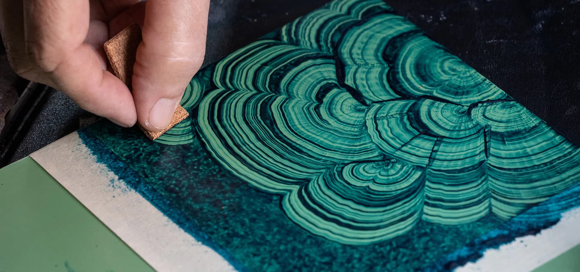 Hand-painted decorative tile with intricate concentric shell or fan pattern in turquoise and navy tones by Isabel O'Neil Studio Workshop.