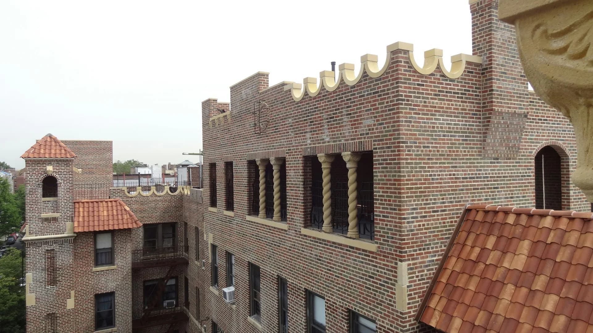 Brick facade with crenellated roofline and arched windows showing contemporary architectural renovation by Ivan Brice Architecture.