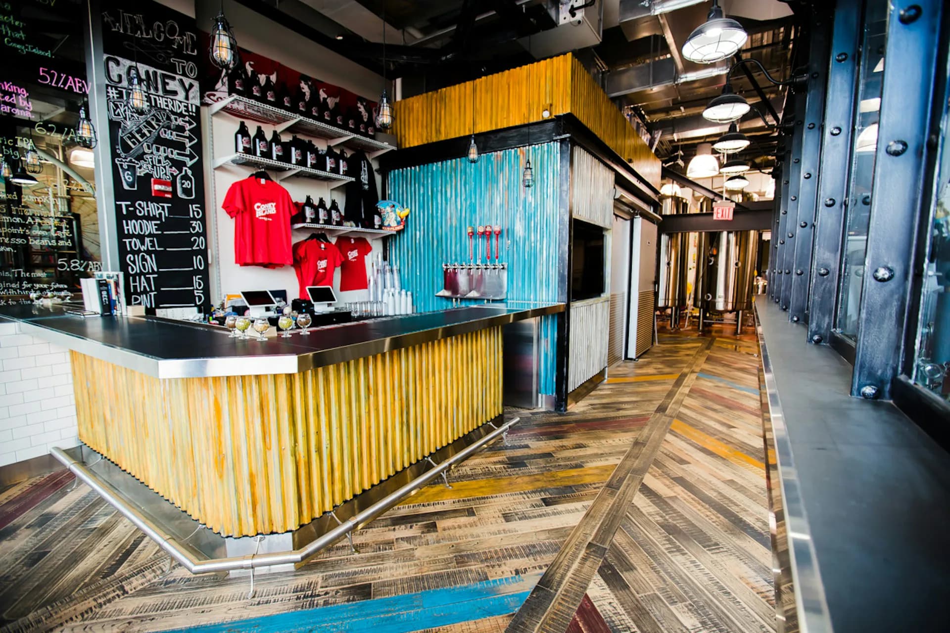 Modern commercial corridor with corrugated metal counter, herringbone wood flooring, and industrial ceiling by Jack L. Gordon Architects.