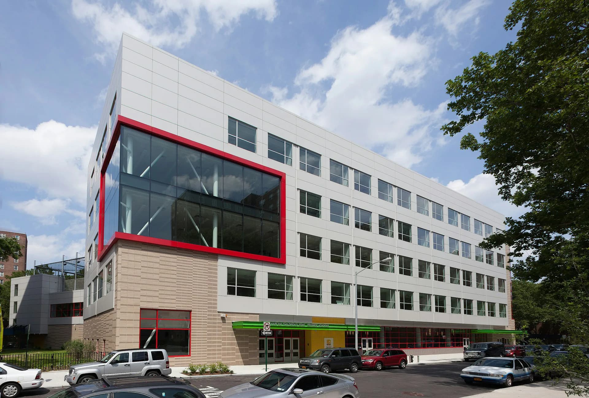 Modern multi-story mixed-use building with red-framed windows, white paneling, and ground-floor retail spaces designed by Ciardullo A&E.