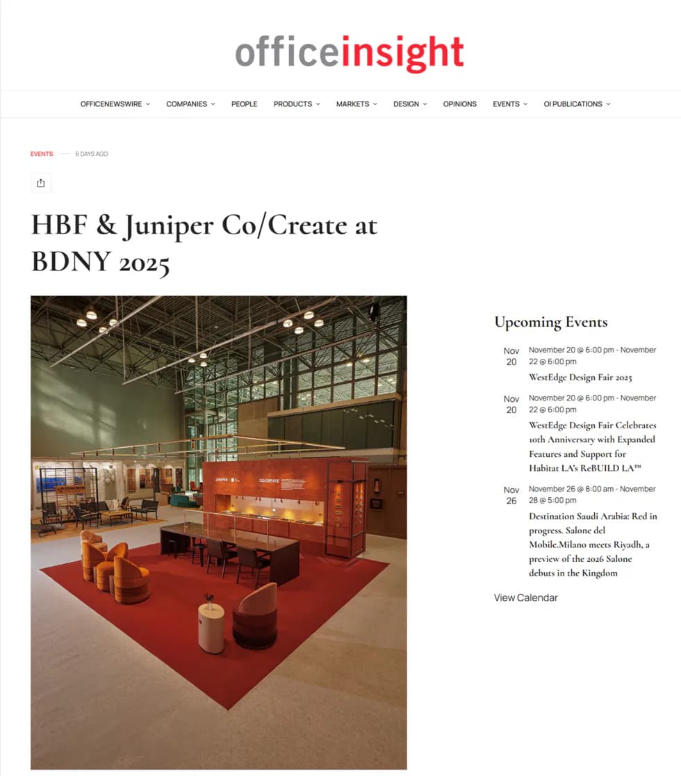 Red exhibition booth with geometric wooden forms and pendant lighting at BDNY 2025, designed by Juniper Design.