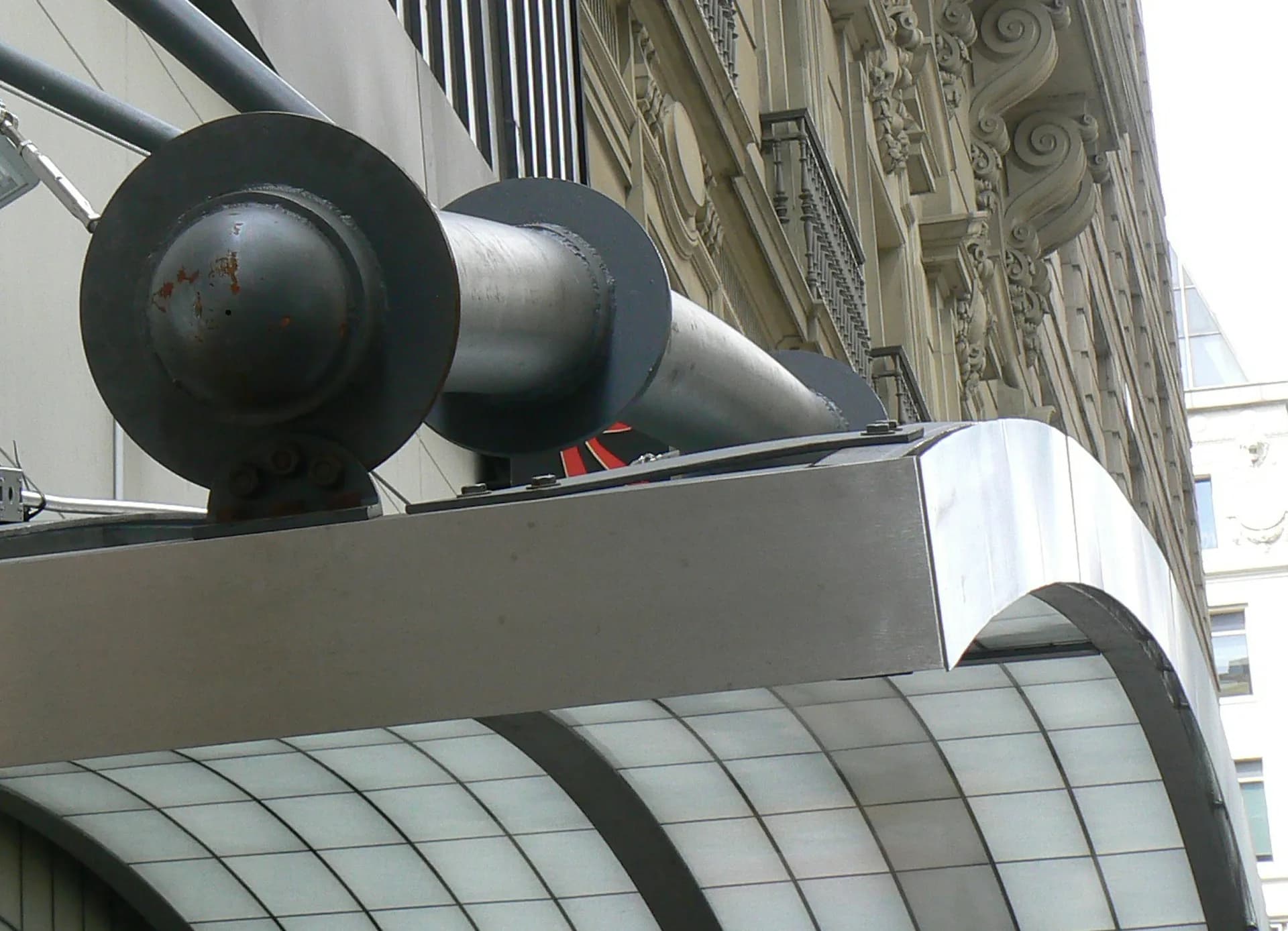 Modern architectural detail showing sculptural spherical forms mounted on a building facade with classical ornamentation, designed by Kleinmann Architects.