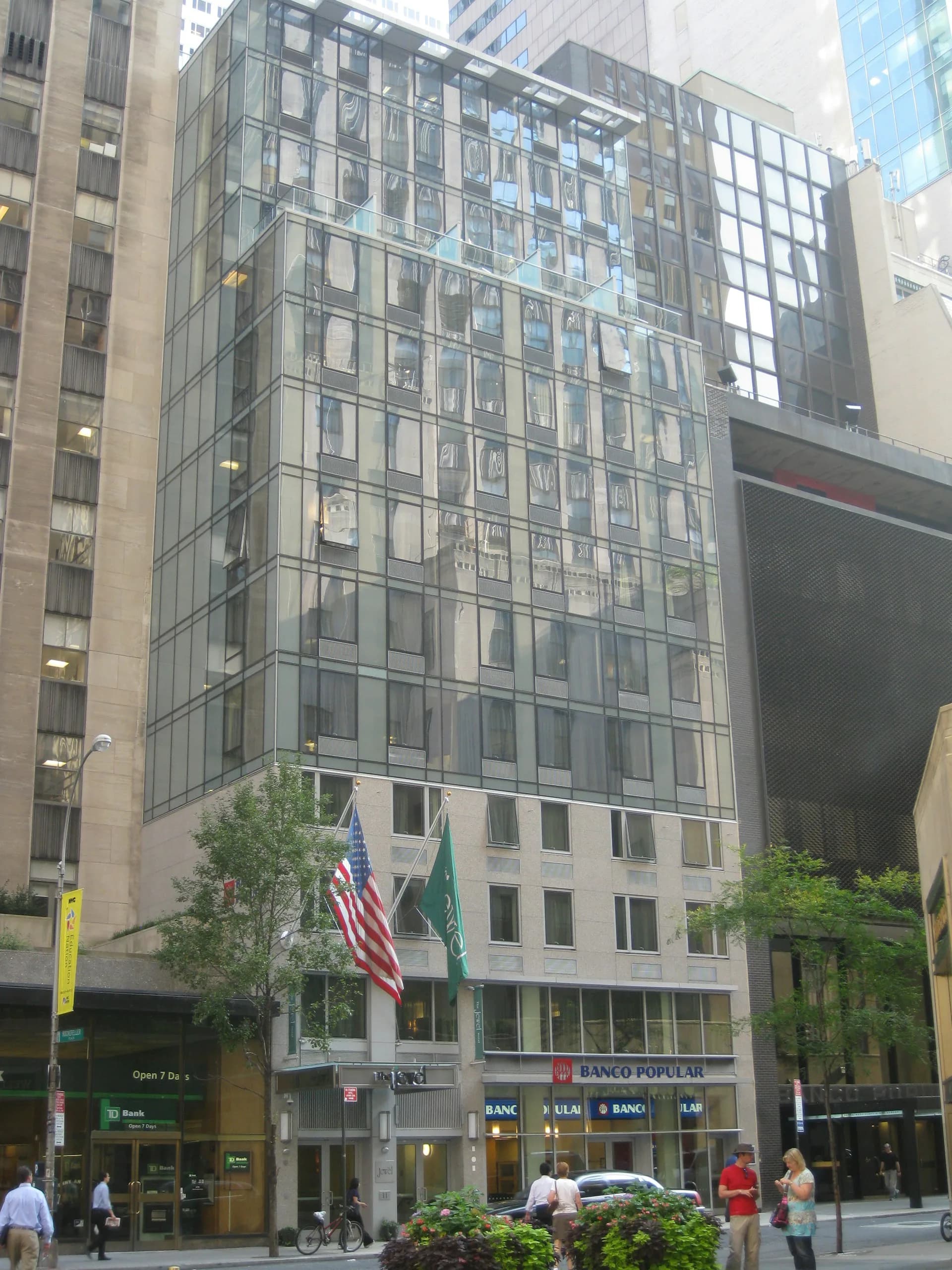 Modern mid-rise office building with steel and glass curtain wall facade, ground-floor retail spaces, and surrounding urban streetscape by Koenen Associates.