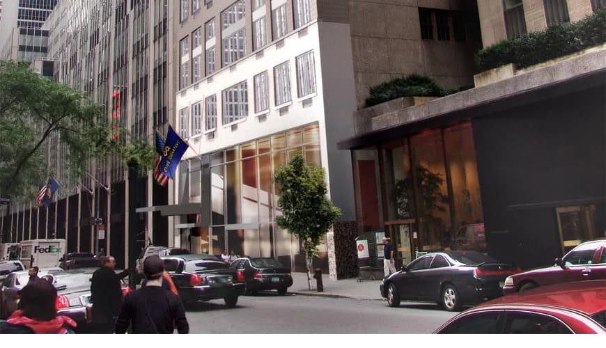 Urban street-level architectural intervention featuring a modernist white facade with integrated storefront on a Manhattan avenue by Koenen Associates.