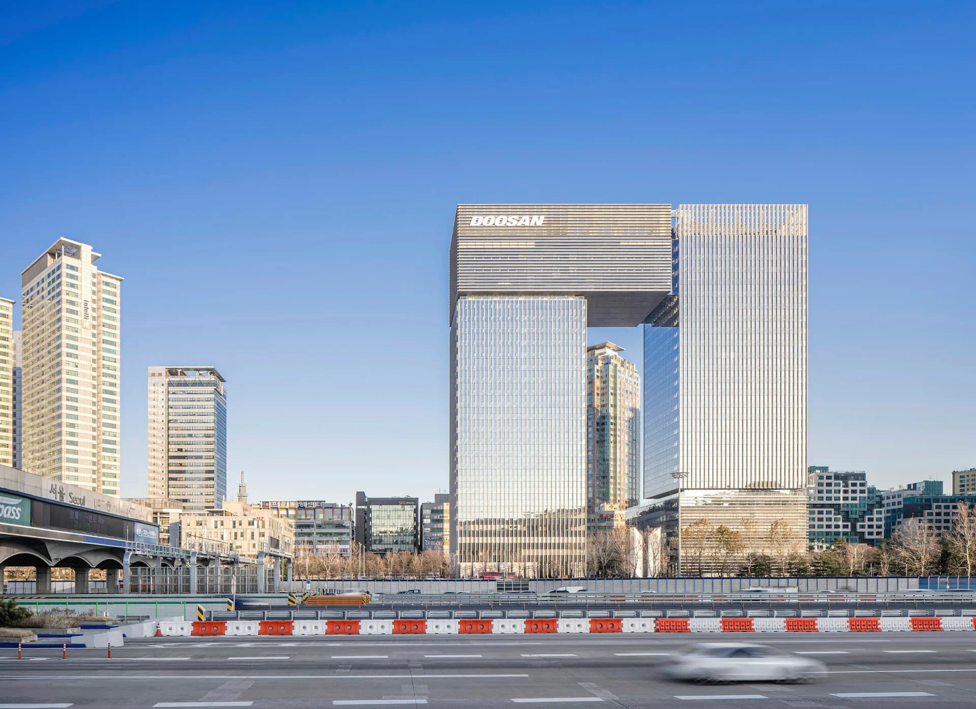 Modern mixed-use tower with distinctive white vertical ribbed facade and cutout design overlooking waterfront plaza by KPF (Kohn Pedersen Fox).
