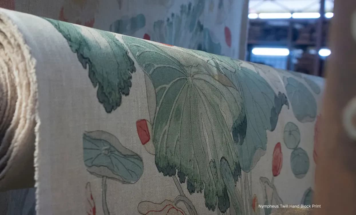Detailed fabric swatch featuring botanical illustrations of plants and flowers in green and red tones on natural linen by Kravet Inc.