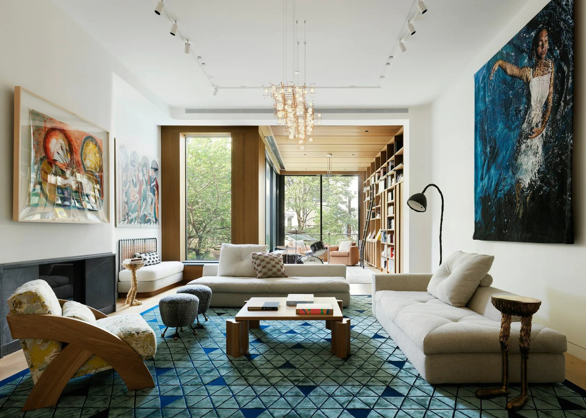Modern living room with gray sofa, blue patterned rug, wooden ceiling detail, and large artworks by Leroy Street Studio.