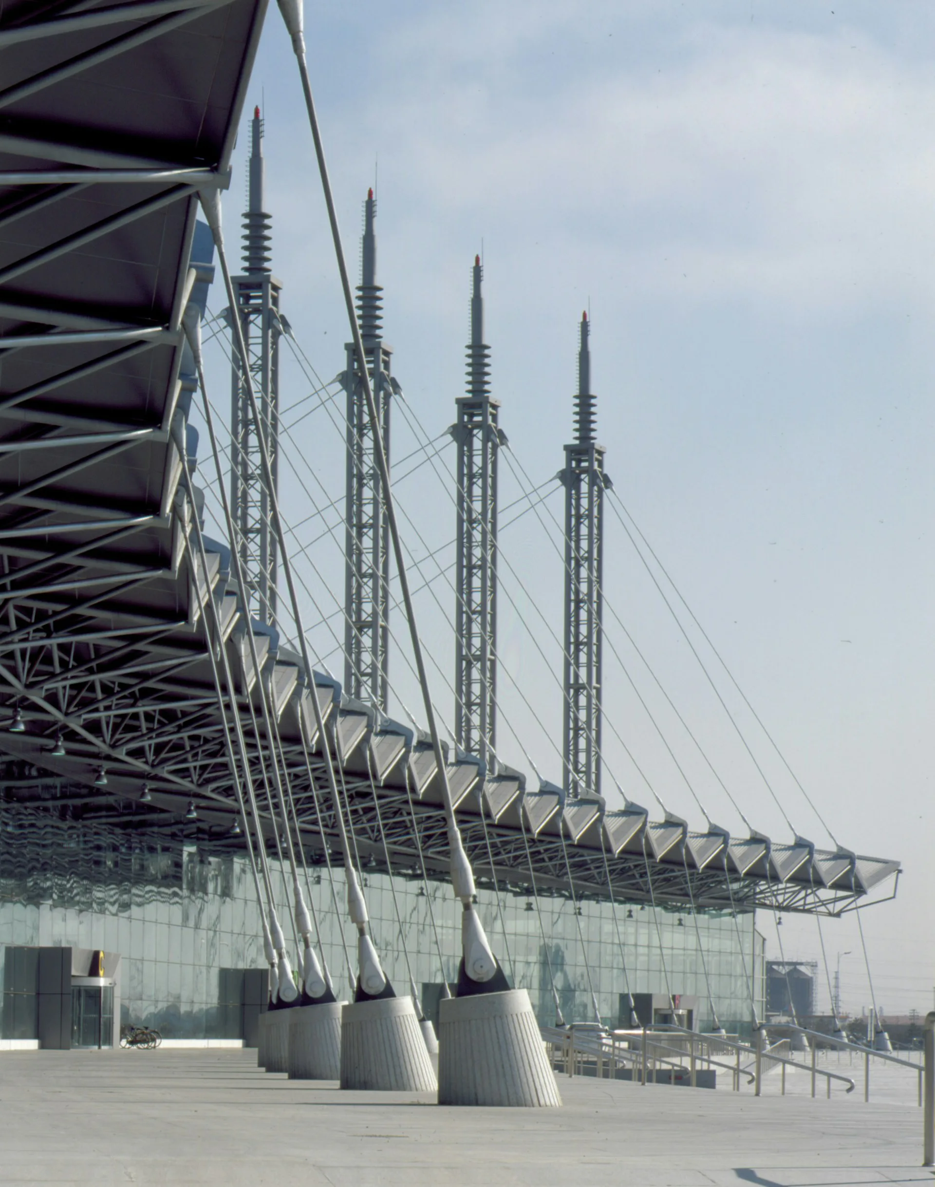 Modern stadium with distinctive white cable-stayed towers and geometric canopy structure, featuring glass facades and clean architectural lines by LHP Architects, PLLC.