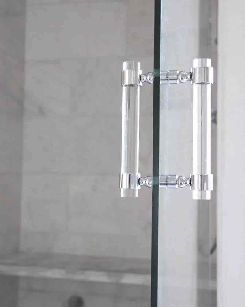 Polished chrome cylindrical door handles mounted on frosted glass doors with minimal hardware detailing by LuxHoldUps.