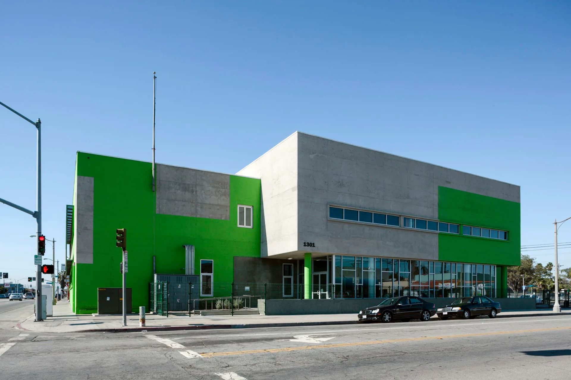 Modern commercial building with striking green and gray facade, large storefront windows, and clean geometric design by LYNCH EISINGER DESIGN Architects.