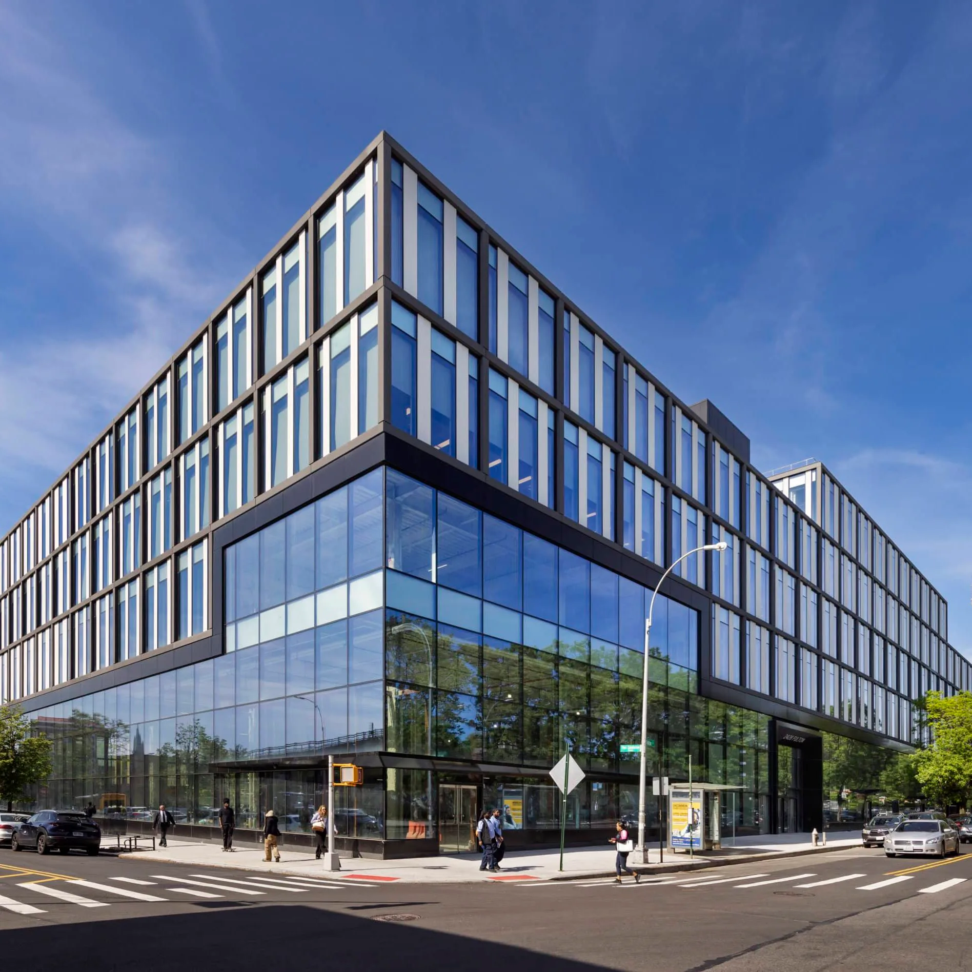 Modern corner office building with dark metal framing, floor-to-ceiling glazing, and clean lines under blue sky, designed by Marvel.