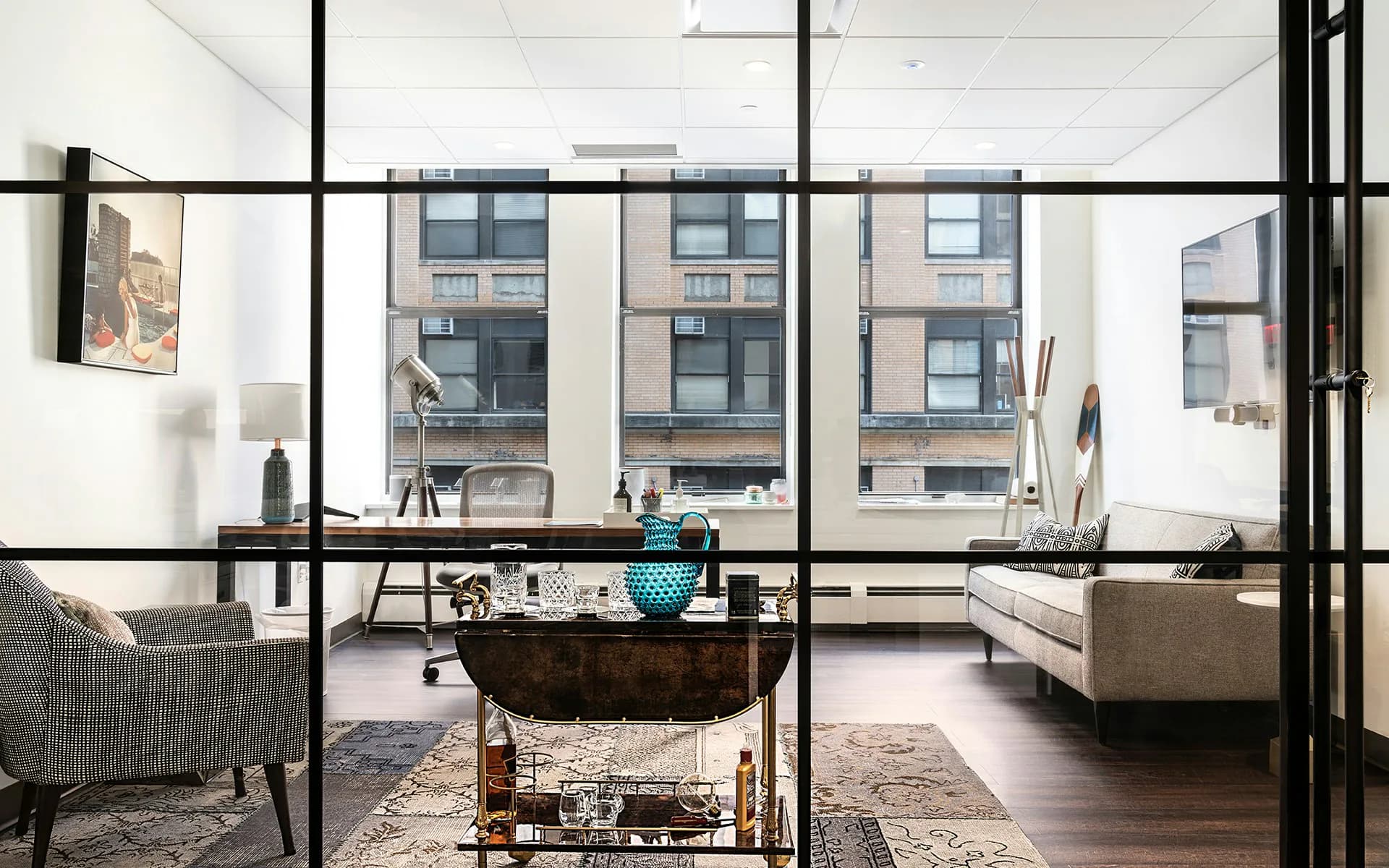 Modern loft interior with floor-to-ceiling windows, industrial black steel framing, neutral palette, and contemporary furnishings by Meridian Design Associates, Architects, P.C.