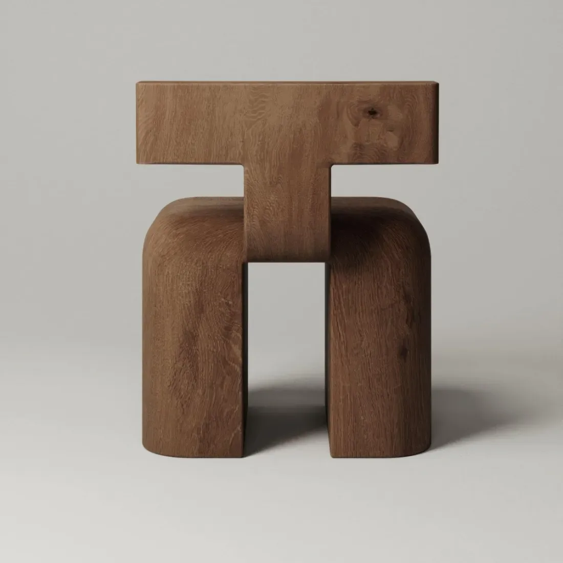 Sculptural wooden furniture piece with geometric forms in warm brown tones, featuring a T-shaped top and curved base elements by Monolith.