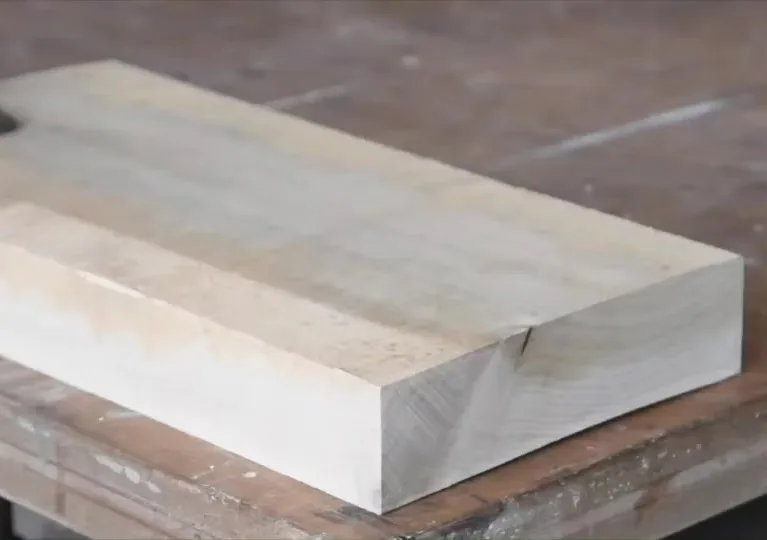 Minimalist white marble or stone rectangular block displayed on a wooden surface, showcasing clean geometric form and material craftsmanship by Nine Stories.