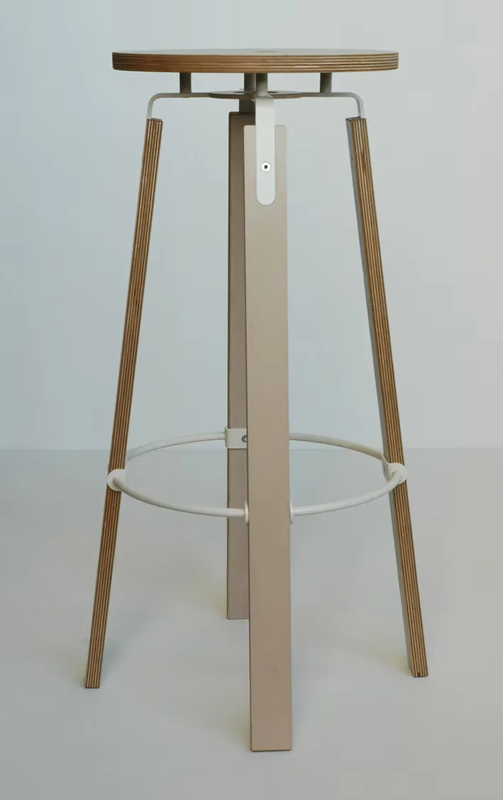 Minimalist bar stool with tapered wooden legs, ribbed metal frame, and circular footrest, designed in natural wood tones by Nine Stories.