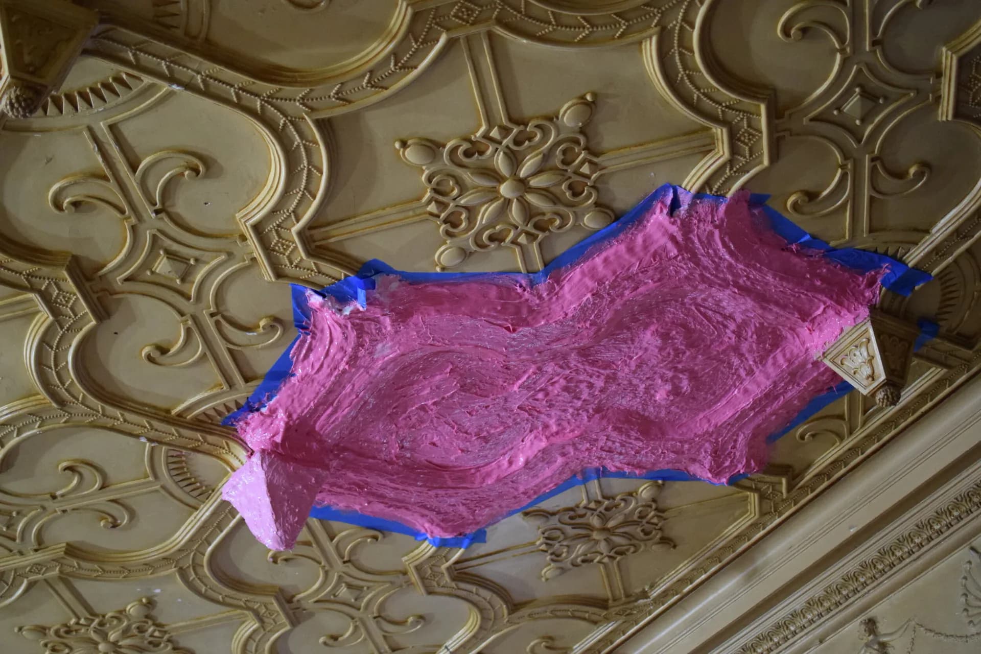 Ornate cream ceiling with classical moldings features a vibrant pink and blue textile installation or sculptural artwork by Open Shop Arts.