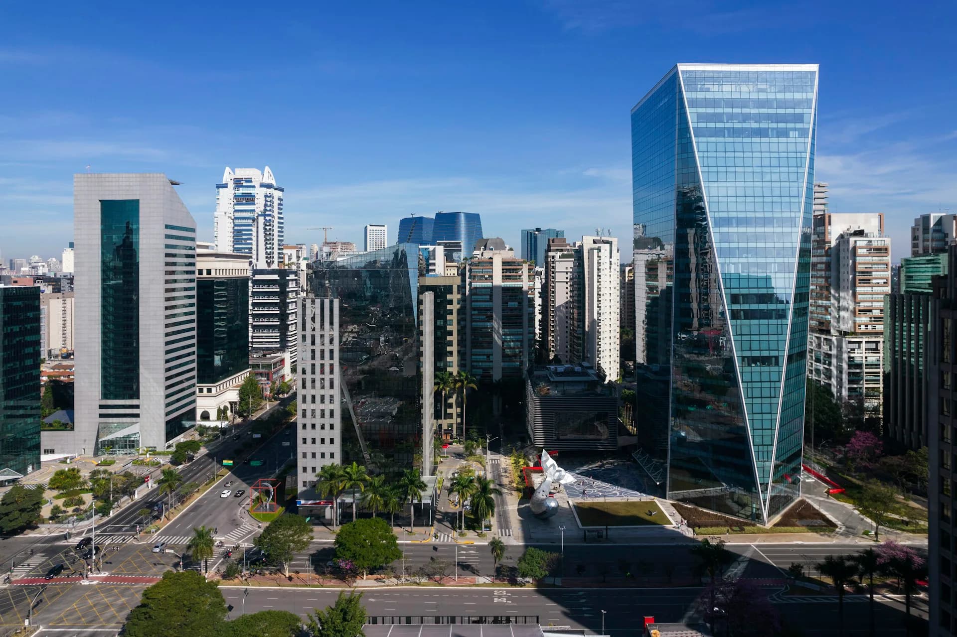 Urban plaza with modern skyscrapers featuring glass and steel facades, green landscaping, and pedestrian walkways in daylight by PEI Architects.