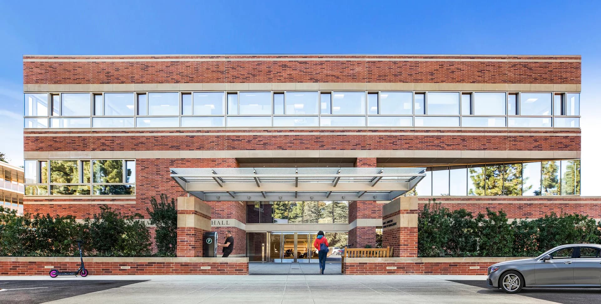 Modern brick institutional building with horizontal banding, glass storefront entrance, and manicured landscaping by Pei Cobb Freed & Partners Architects LLP.