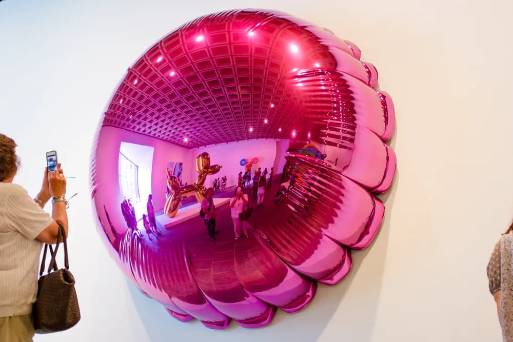 Pink inflatable spherical installation with ribbed texture and integrated lighting, displayed in gallery space with visitors, by Prototype New York.