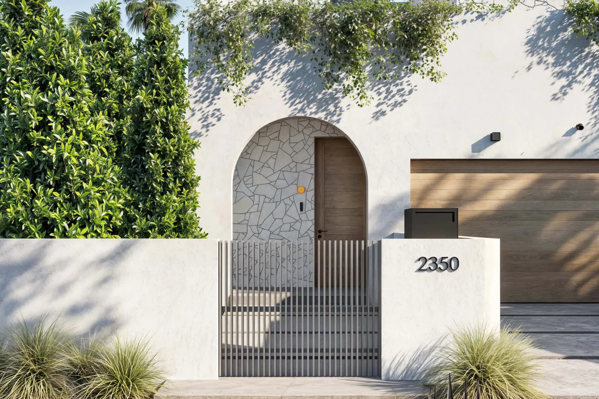 Modern residential entrance with arched doorway, vertical slat gate, white stucco walls, native plantings, and address number 2350 by RBW.