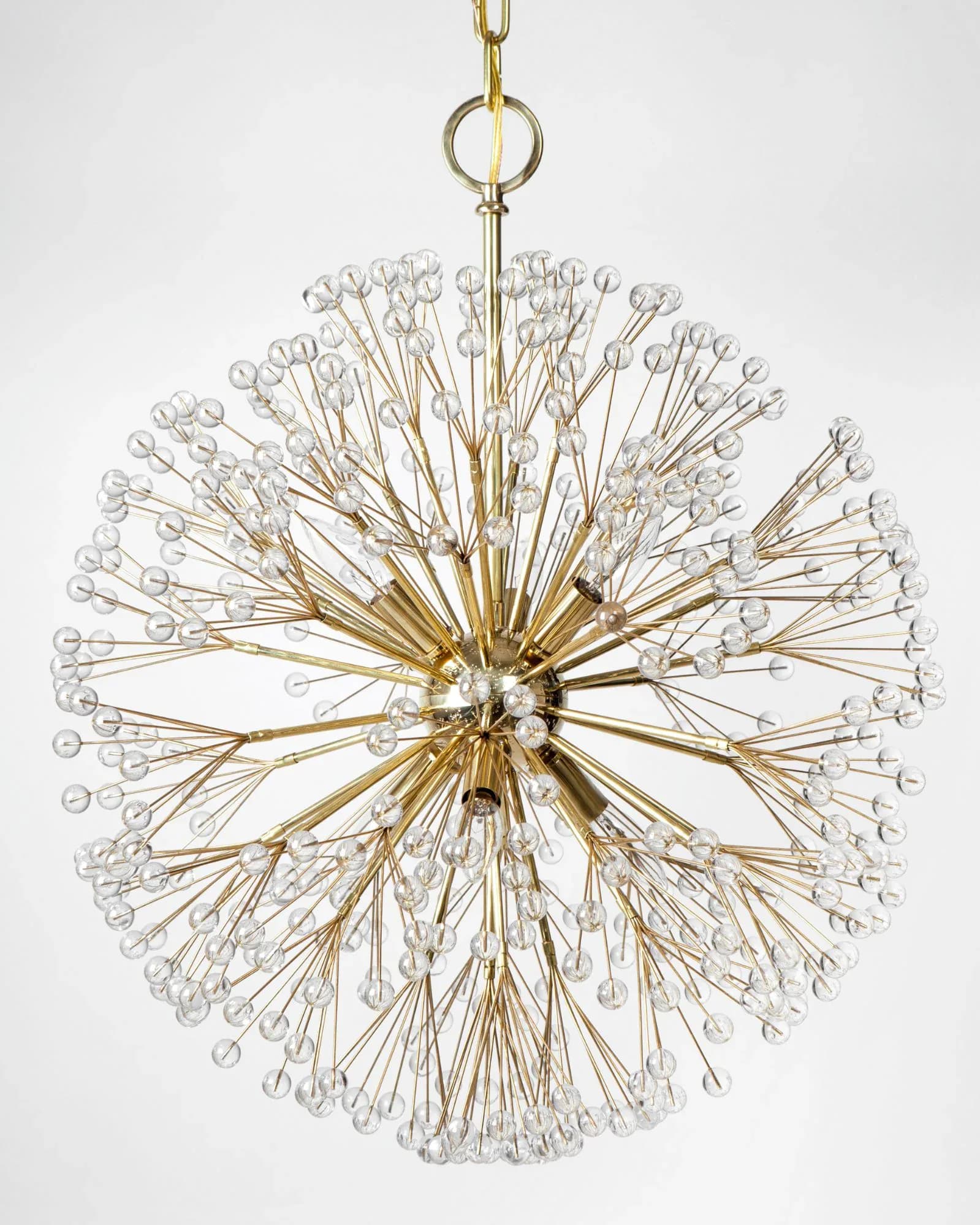 Brass starburst pendant chandelier with delicate glass ball terminals radiating outward, suspended against white background by Remains Lighting Company.