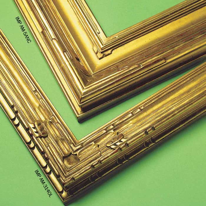 Gold-finished picture frame samples with decorative molding details arranged on a green background by Rhonda Feinman Custom Frames, Inc.