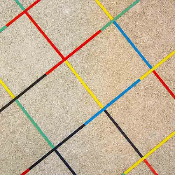 Terrazzo flooring with colorful tape lines creating a geometric pattern in red, blue, yellow, green, and black by Richard Bloch Architect.
