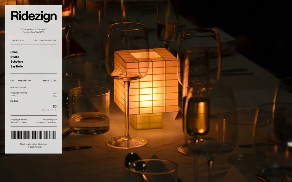 Warm-lit interior scene featuring a glowing cubic latticed light fixture surrounded by glass vessels on a dark surface, designed by Ridezign.