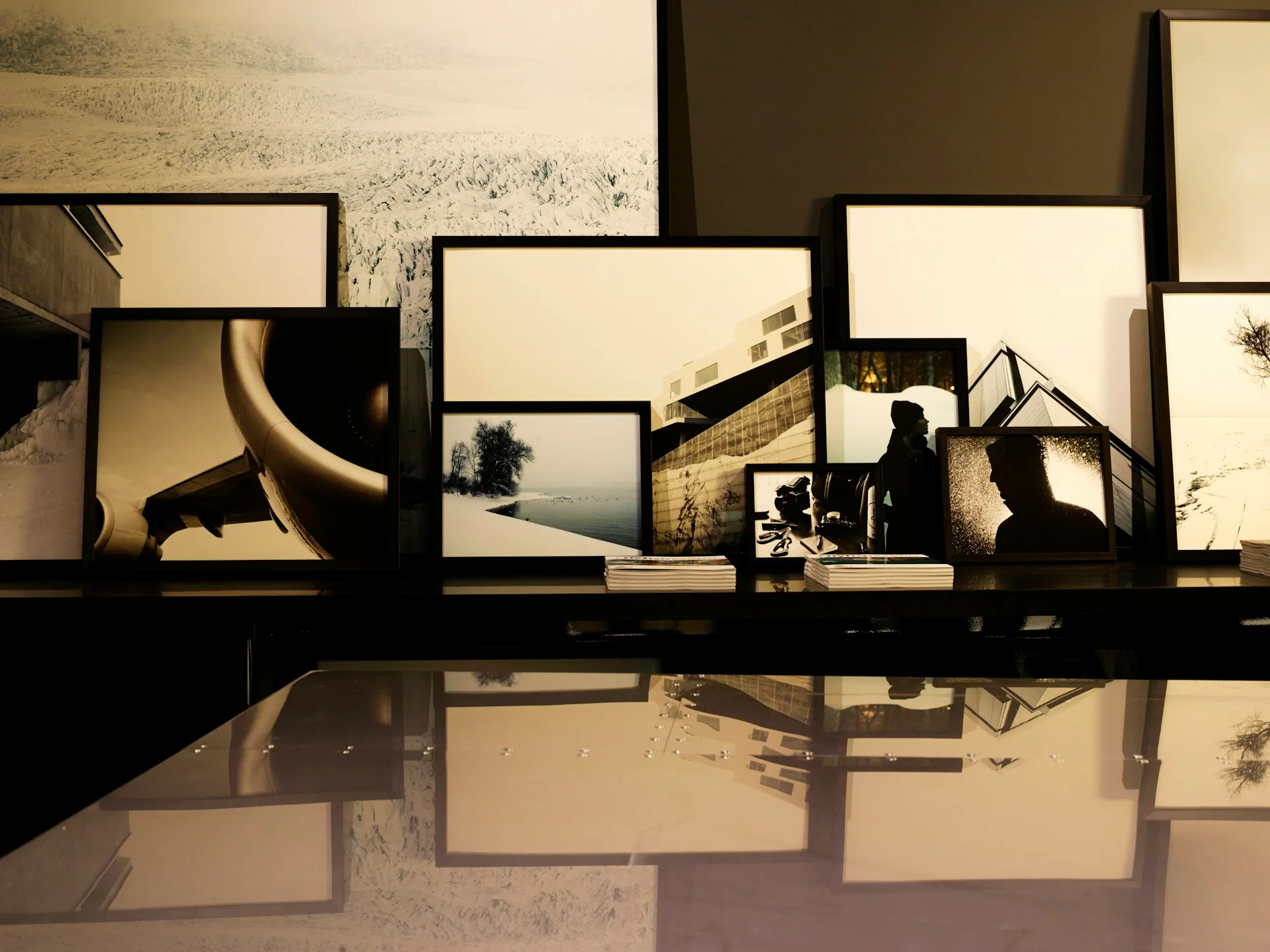 Silhouetted architectural model with illuminated frames and layered spatial elements casting reflections on a glossy surface by Rise Projects.