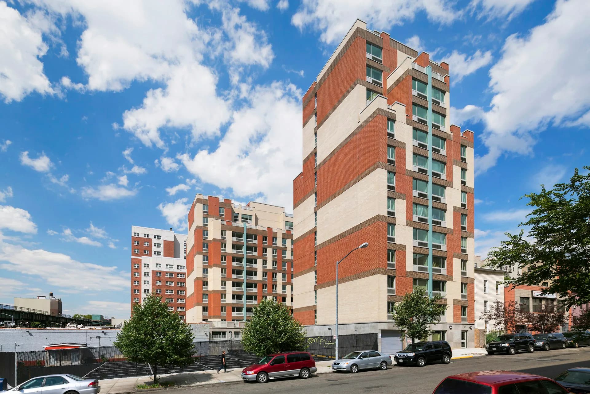 Red-brick and cream residential apartment building with horizontal striped facade and multiple stories, designed by RKTB Architects, P.C.