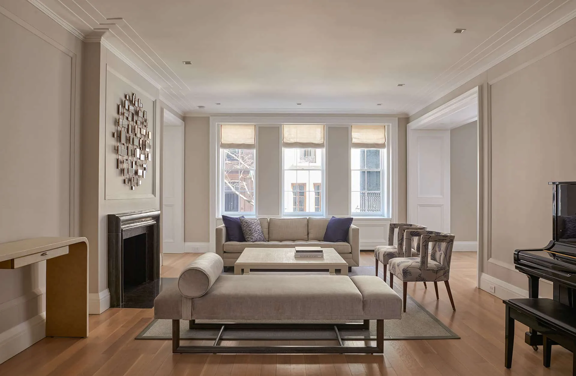 Contemporary living room with neutral palette, large windows, gray seating, wooden flooring, and modern furnishings designed by Rodman Paul Architects, PLLC.