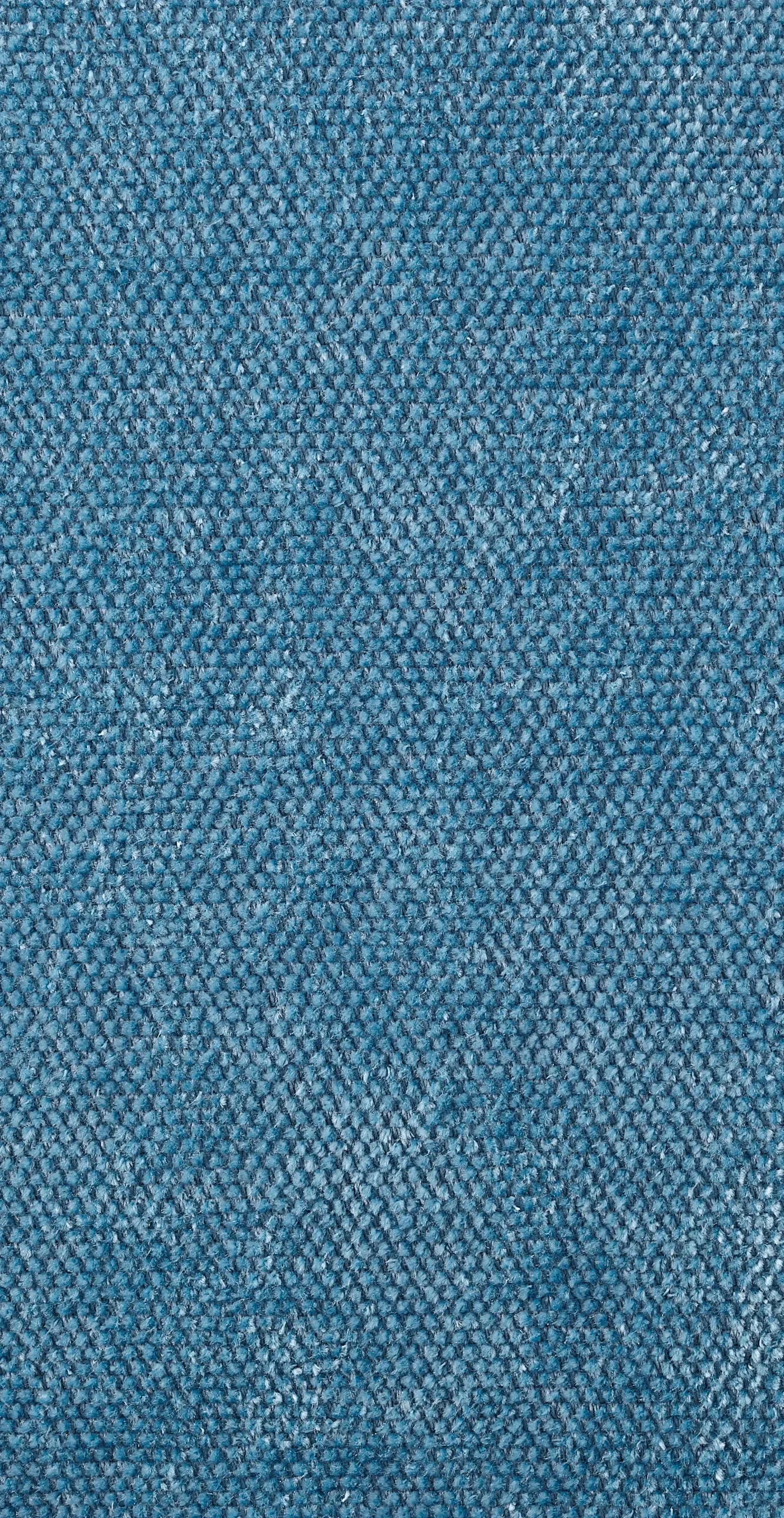 Close-up of a textured blue fabric sample with woven geometric pattern, showcasing material selection by Rogers & Goffigon.