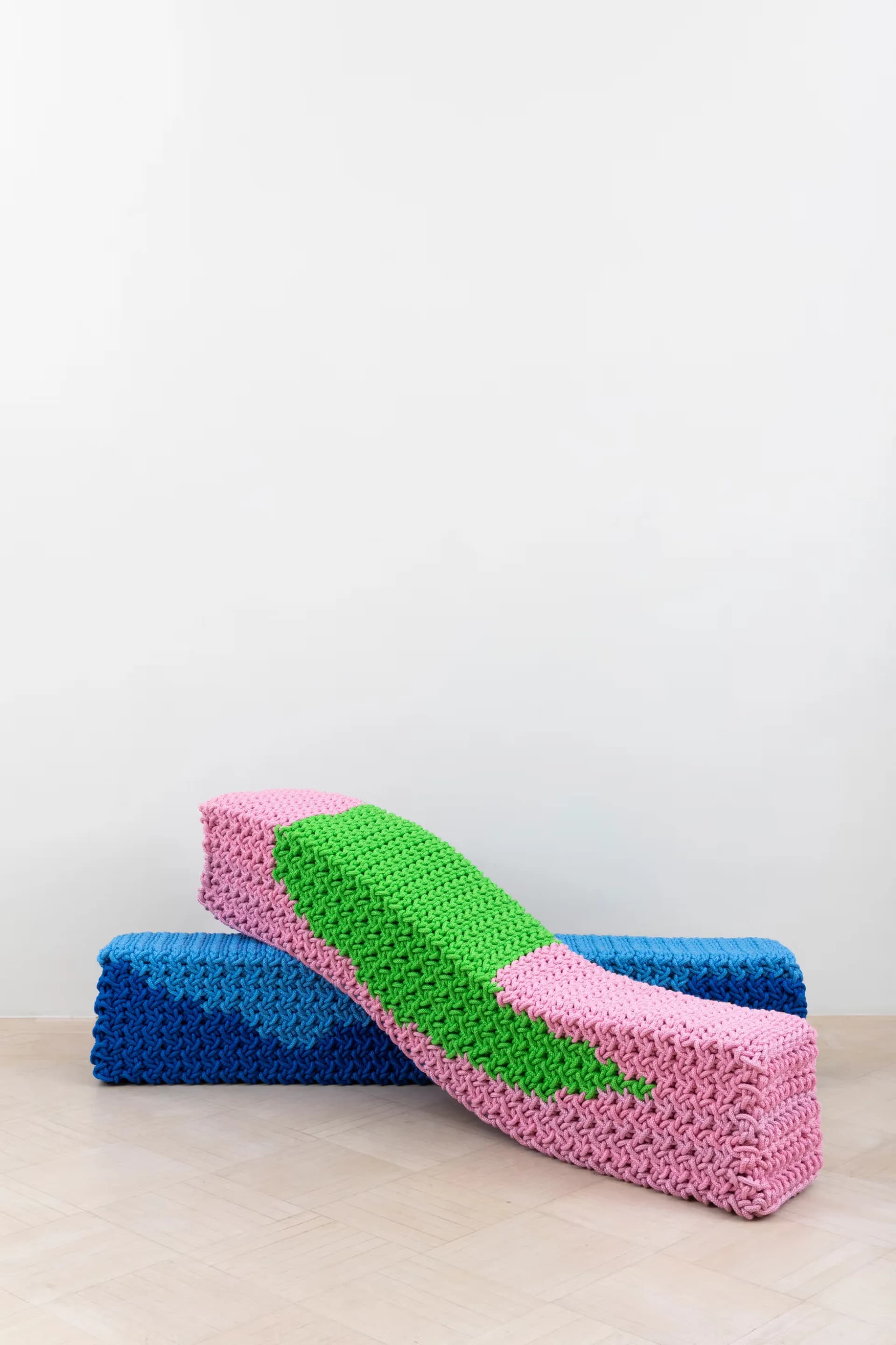 Colorful sculptural installation with interlocking blue, pink, and green textured blocks creating an abstract curved form by Salon 94 Design.