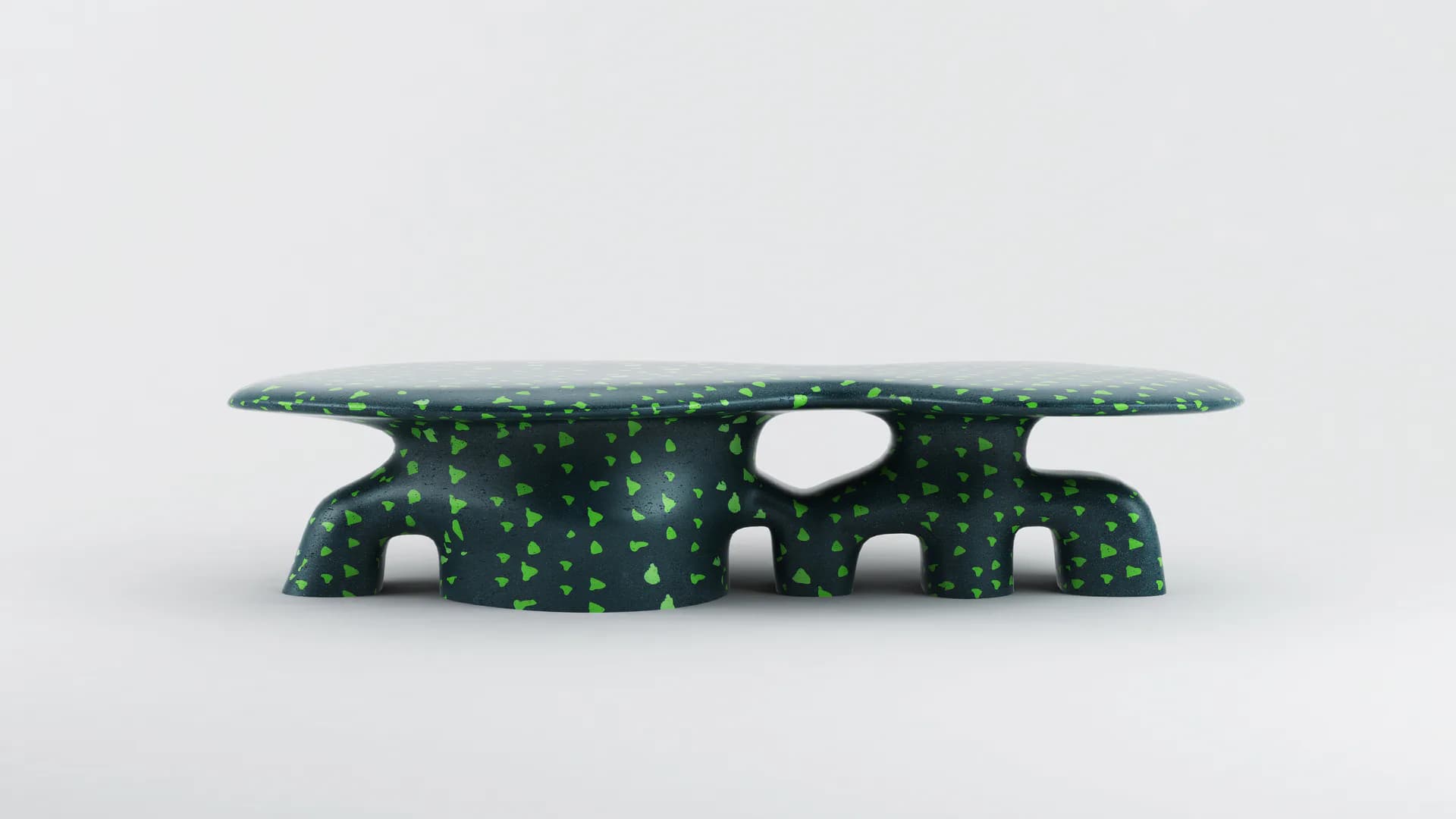 Green textured sculptural bench with organic cutout forms and a long flat top surface, featuring repeating dot patterns and white oval openings, by Sayar & Garibeh.