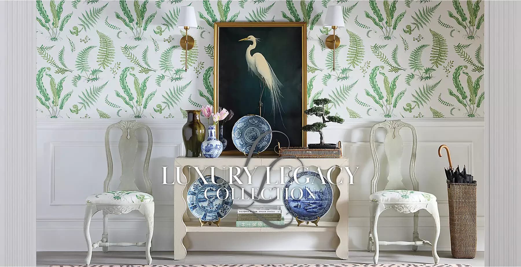 Elegant foyer with fern-patterned wallpaper, cream upholstered chairs, decorative blue and white ceramics, and a heron portrait by Scalamandré.