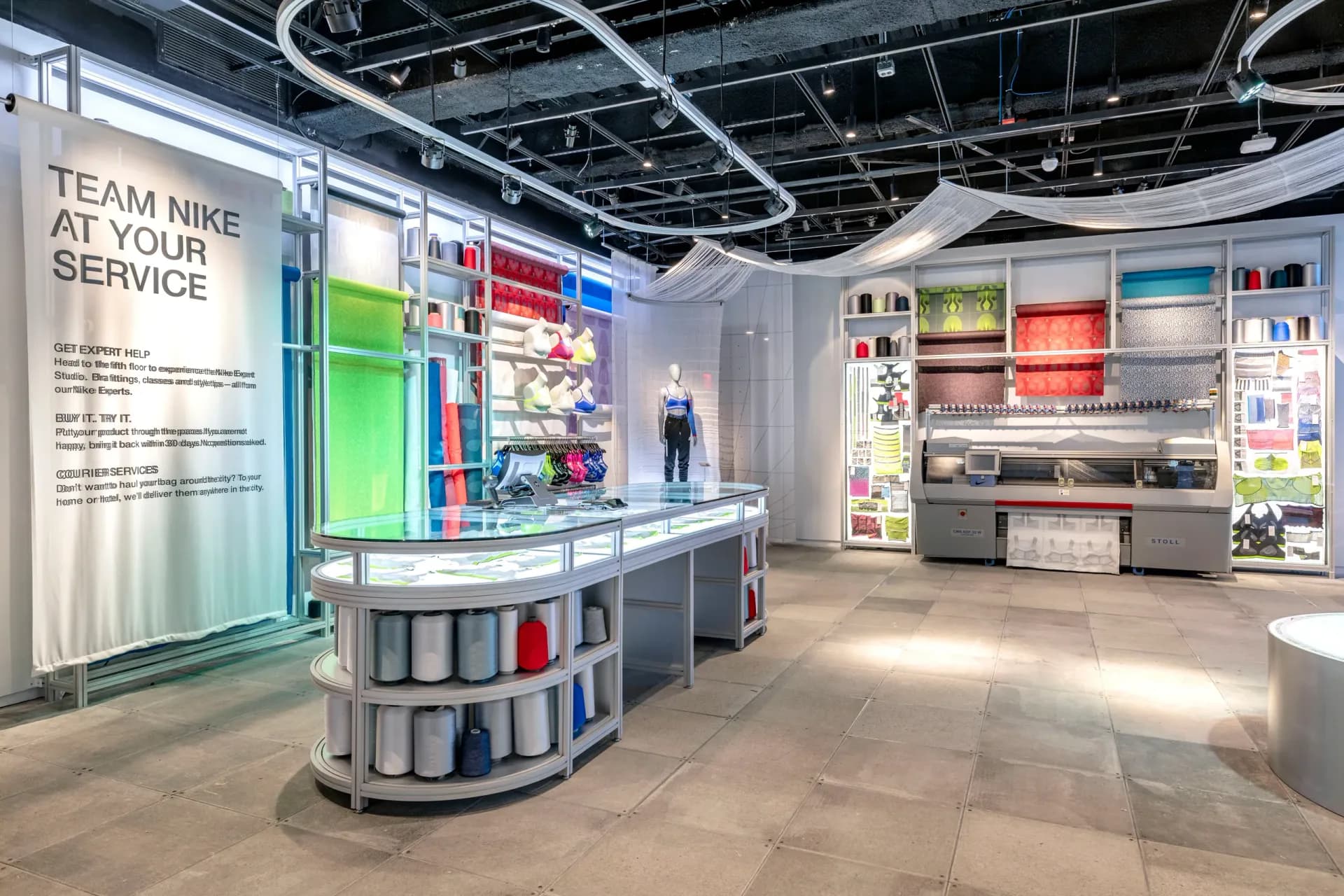 Modern retail interior with curved display counter, colorful product shelving, and bright ceiling lighting, designed by Scenicorp.