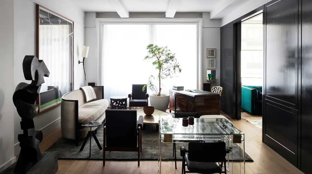 Modern living room with black and white furnishings, glass coffee table, large windows, and minimalist decor by Scott Springer Architect LLC.