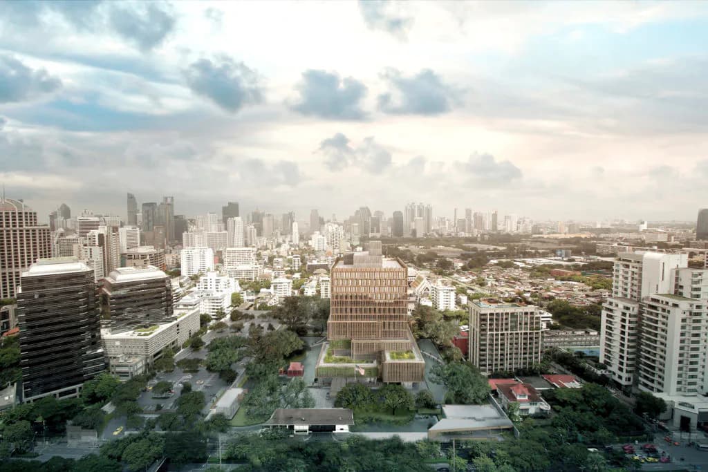 Aerial view of a verdant public plaza surrounded by urban high-rises under cloudy skies, designed by SHoP Architects.