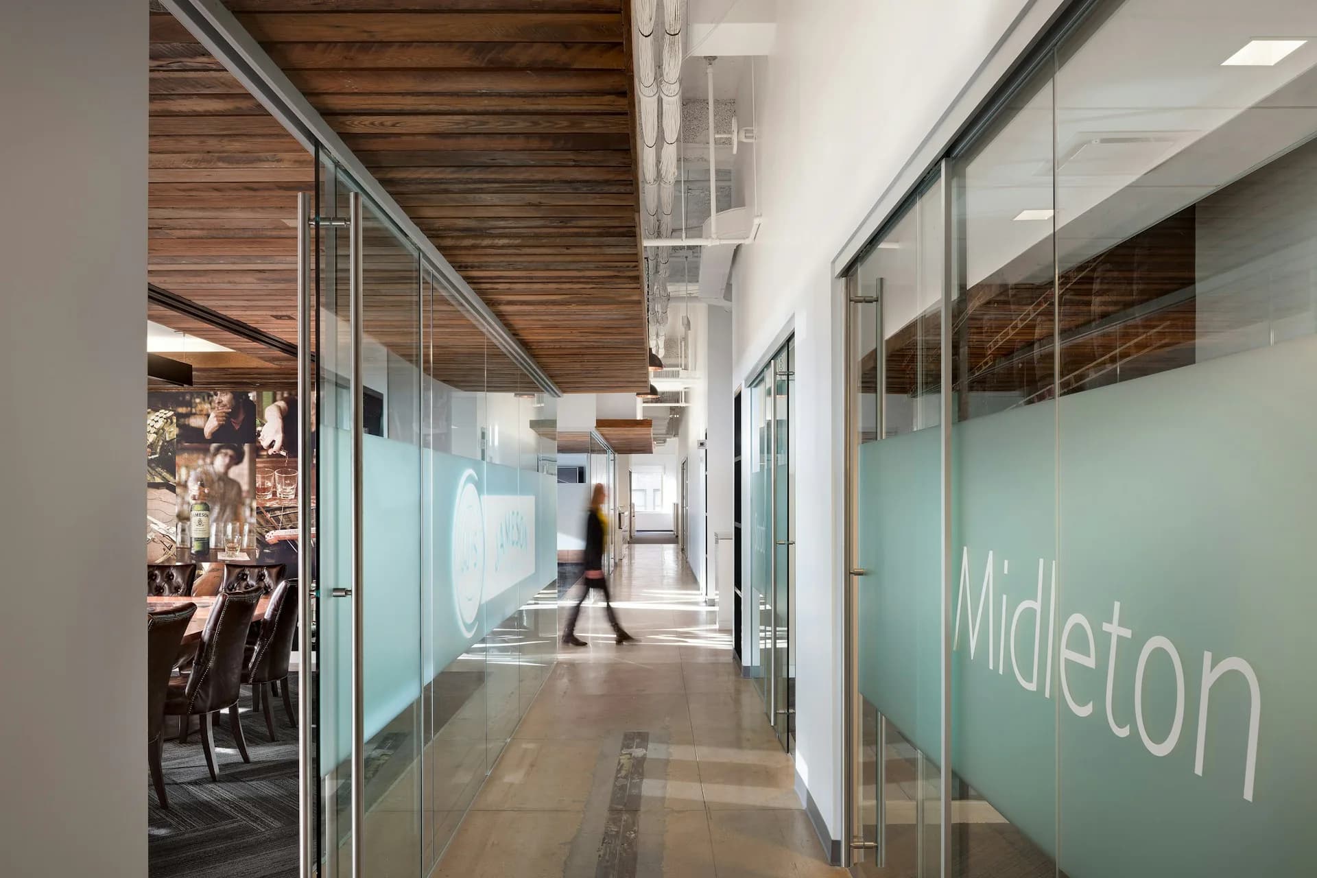 Modern office corridor with frosted glass partitions, wooden ceiling details, and mint green branded signage for Midleton by Spectorgroup.