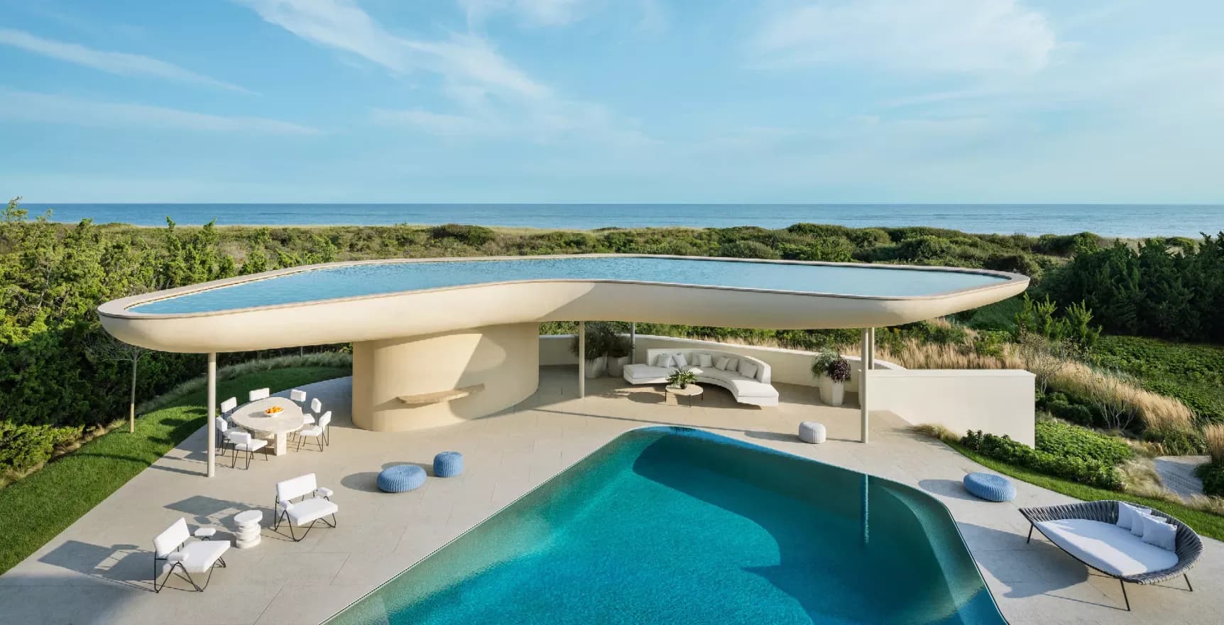 Modern curved residential architecture with turquoise pool overlooking ocean, featuring cantilevered concrete design by Steven Harris Architects.
