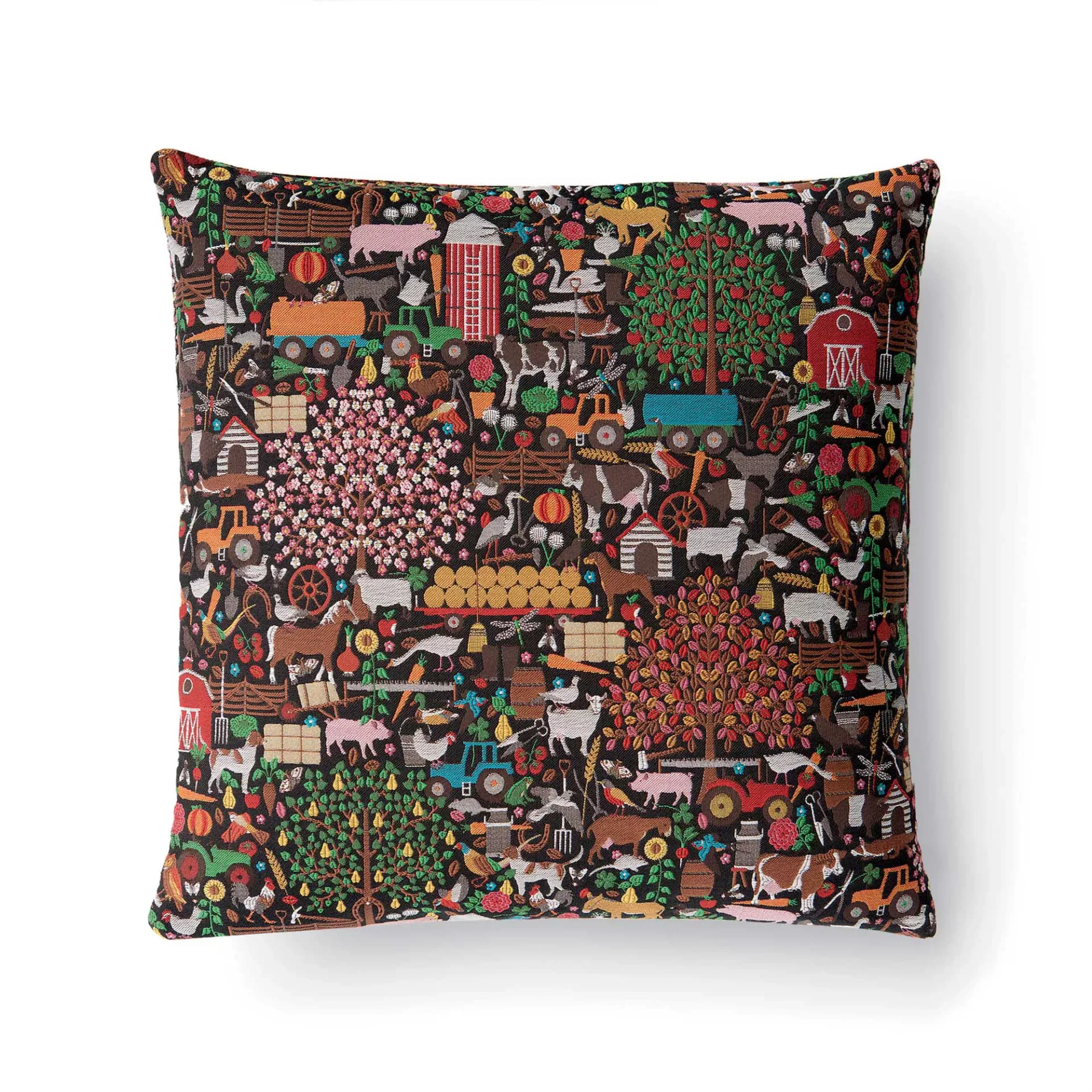 Vibrant patterned throw pillow featuring a dense collage of illustrated farm animals, tractors, and rural motifs in warm earth tones and bright accents by Studio Job.