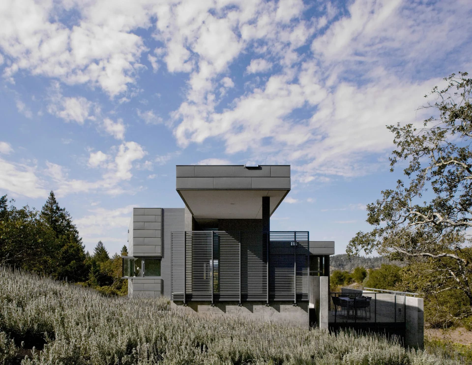 Modern residential architecture with stacked concrete volumes and horizontal louvers set in a sagebrush landscape by Studio Joseph.
