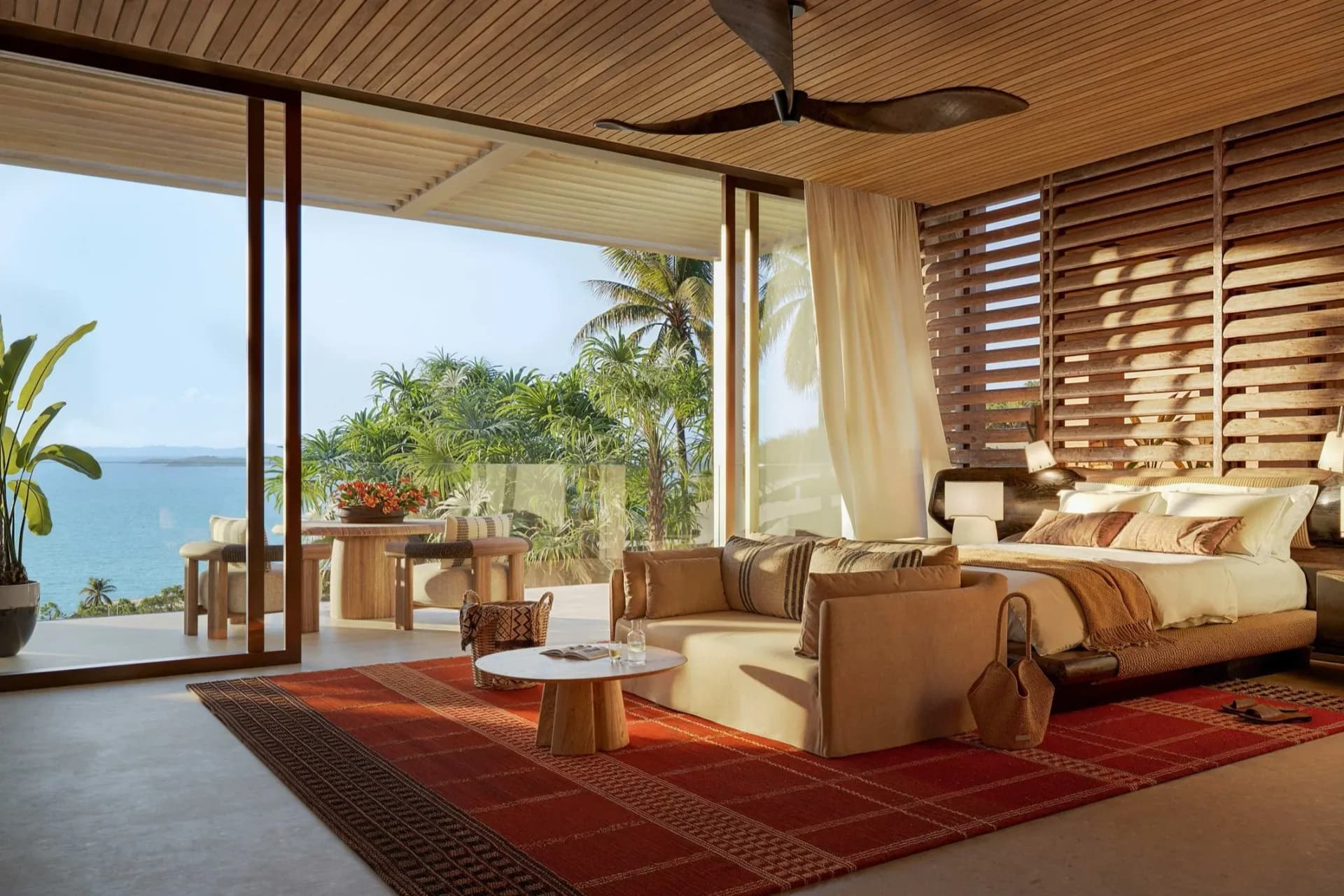 Luxurious coastal bedroom with ocean views, featuring warm wood ceiling, natural materials, and synthetic lighting typical of architectural visualization by Studio Paolo Ferrari.