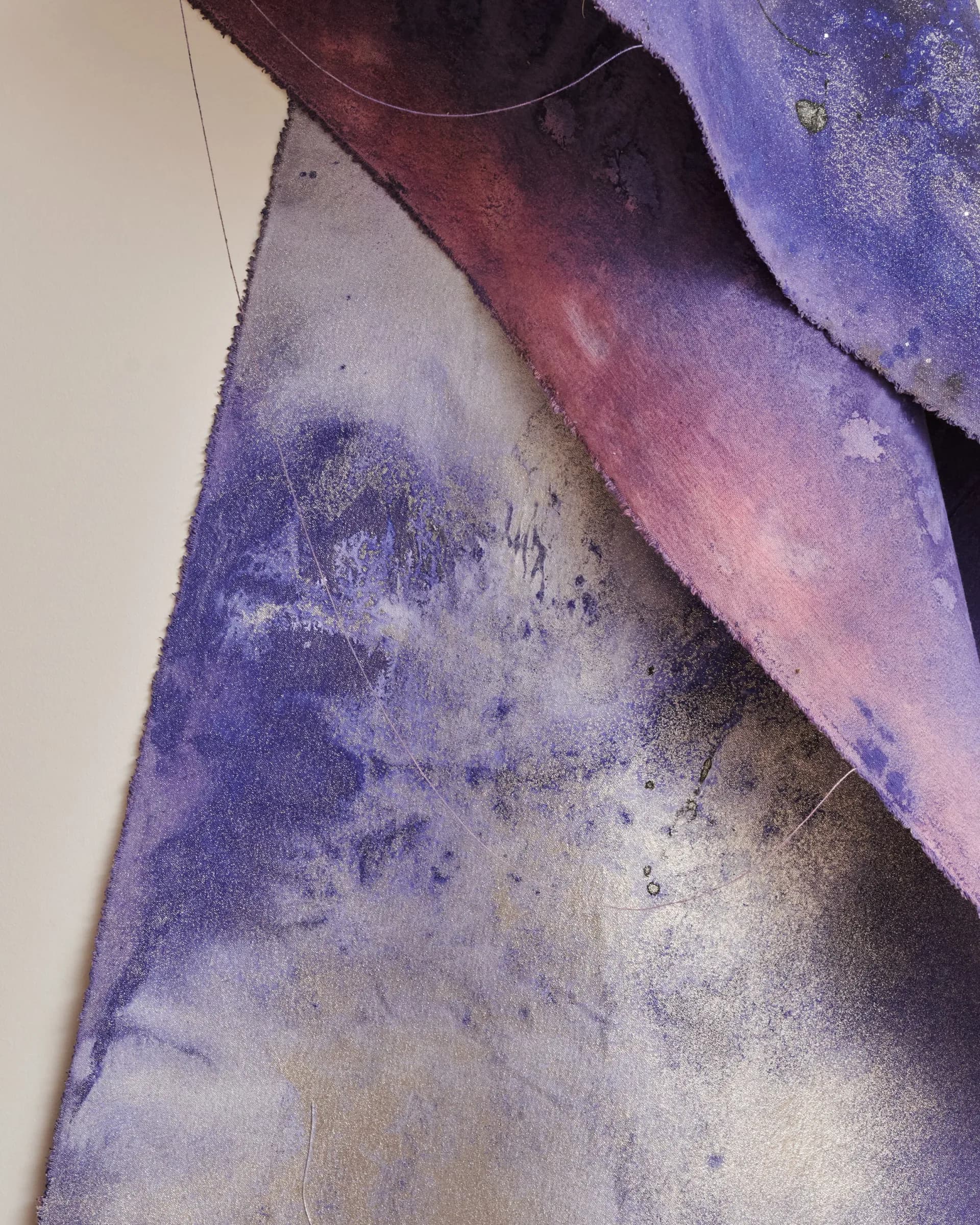 Layered fabric surfaces in purple, mauve, and neutral tones with textured finishes and draped forms, showcasing material exploration by Superhouse.