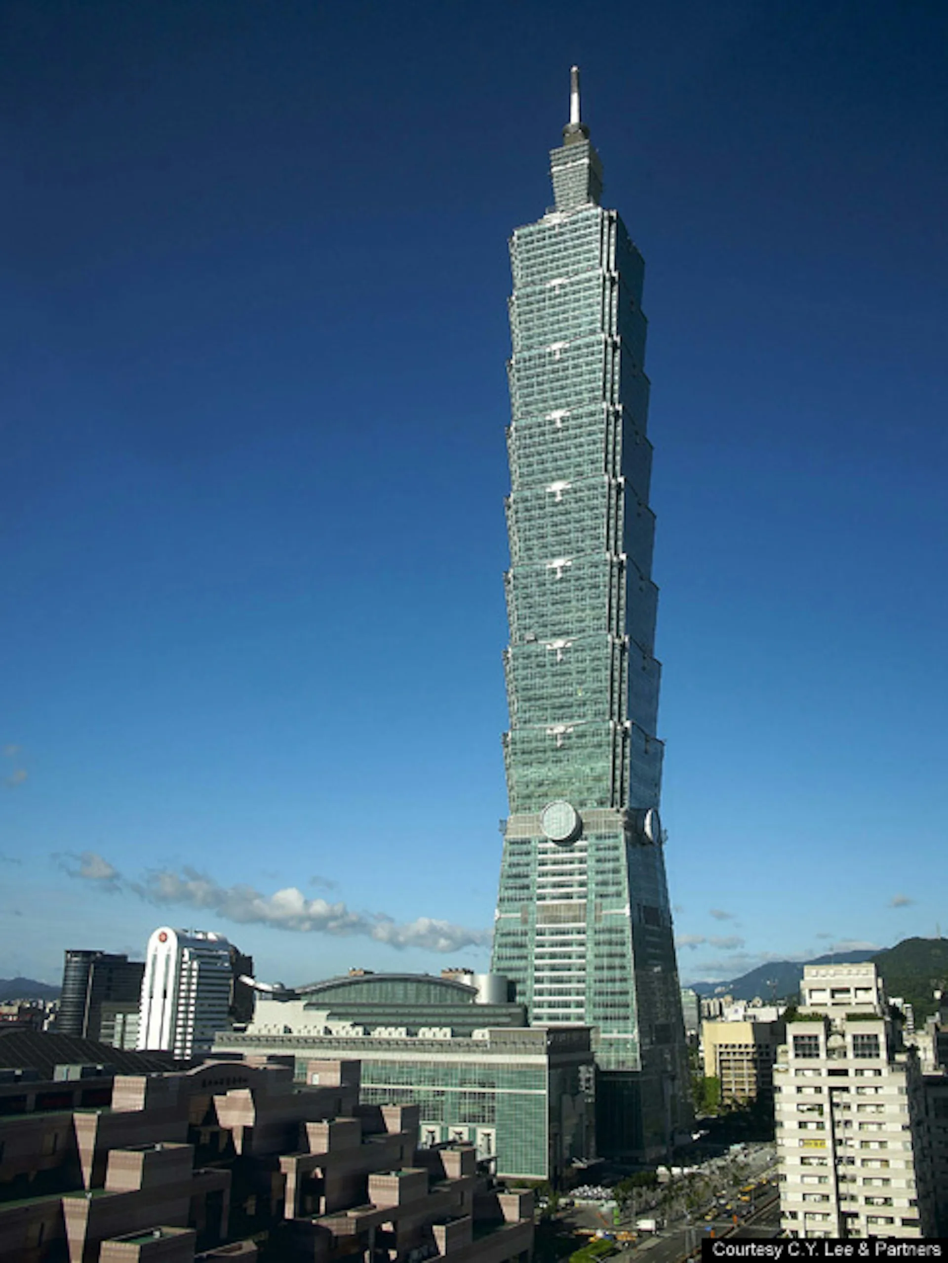 Taipei 101 supertall skyscraper with distinctive green-tinted glass facade and segmented tower design against clear blue sky, designed by Thornton Tomasetti.