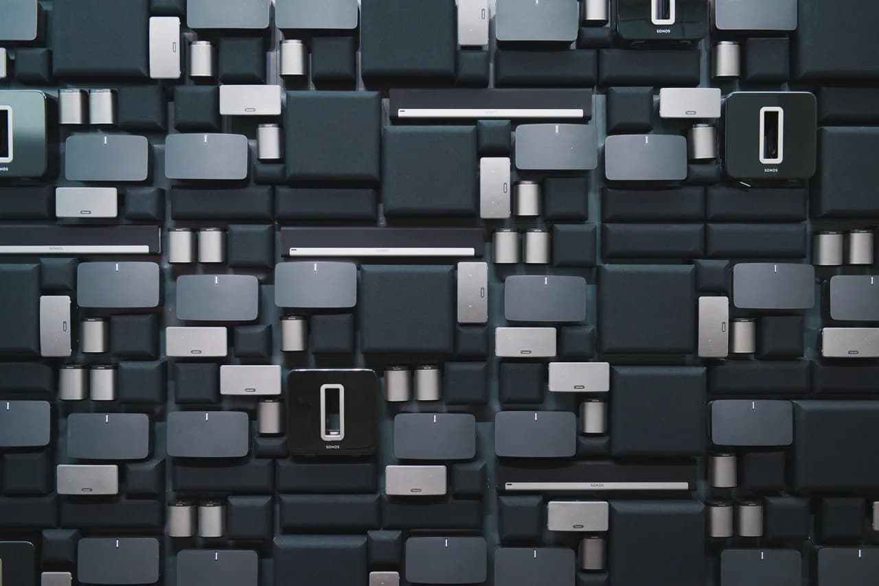 Abstract 3D wall installation featuring stacked geometric blocks in charcoal, gray, and white tones with varying depths and dimensions by Tietz-Baccon.